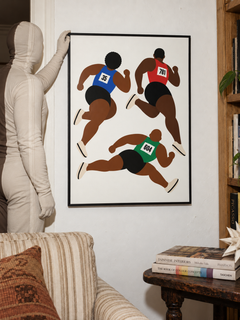 Fly Brothers framed running print in a collected room with a camouflaged figure adjusting the frame.